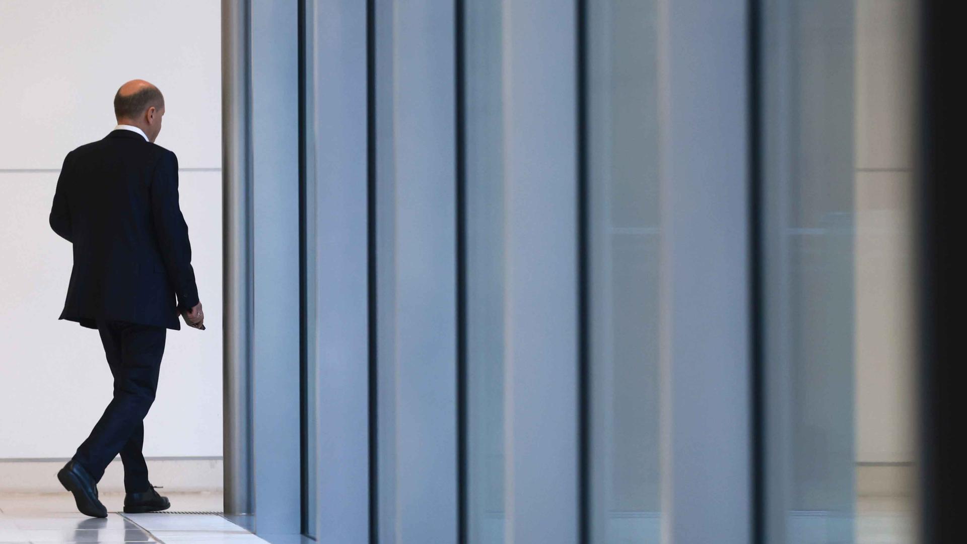 Scholz von hinten, beim verlassen einer Halle. 