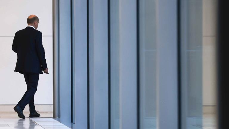 Scholz von hinten, beim verlassen einer Halle. 