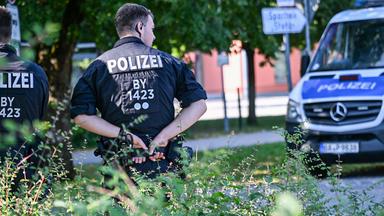 Kräfte der bayerischen Polizei stehen am 09.07.2026 in der Nähe des Welfen-Gymnasiums in Schongau.