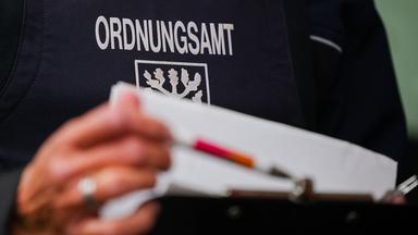  Eine Beamtin vom Ordnungsamt der Stadt Hagen blättert in ihren Unterlagen bei einer Kontrolle, die im Kampf gegen kriminelle Geschäftsmodelle mit Schrottimmobilien und Sozialbetrug stattfindet.