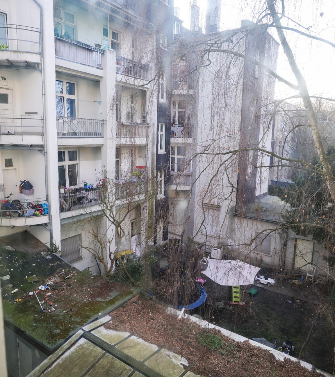 Blick aus dem Fenster eines Hausflurs einer Schrottimmobilie in einen Innenhof.