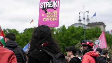 08.05.2026, Berlin: Auf einem Plakat auf einer Demonstration steht «Streik! Geld für Soziales statt Krieg».