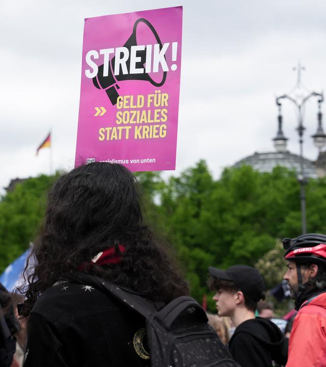 08.05.2026, Berlin: Auf einem Plakat auf einer Demonstration steht «Streik! Geld für Soziales statt Krieg».
