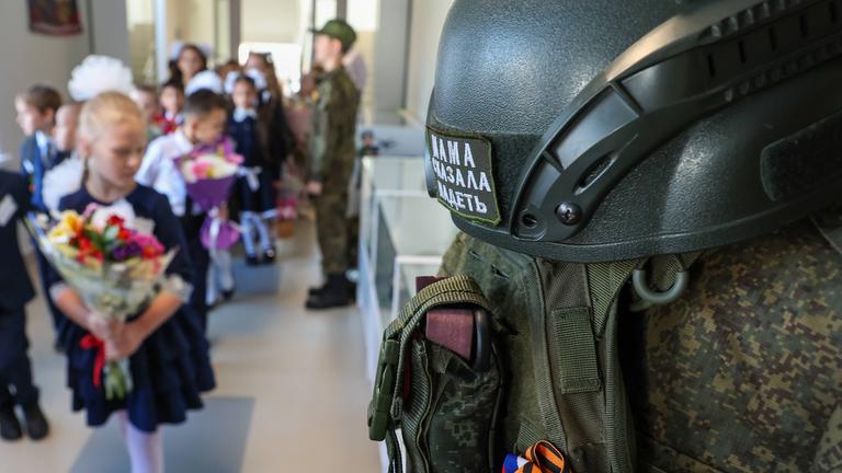 Eine Reihe von Kampfausrüstungen hängt zur Schau, während Schüler am Tag des Wissens, am 01.09.2025, zum Beginn des neuen Schuljahres in die Klasse der Sekundarschule Nr. 87 in Jekaterinburg, Russland, gehen.