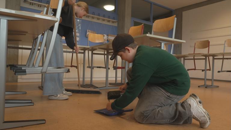 Schüler, die ihren Klassenraum putzen