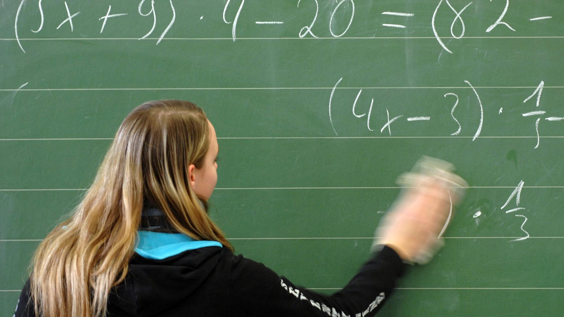 Schülerin wischt im Klassenzimmer einer Hauptschule in Straubing die Tafel
