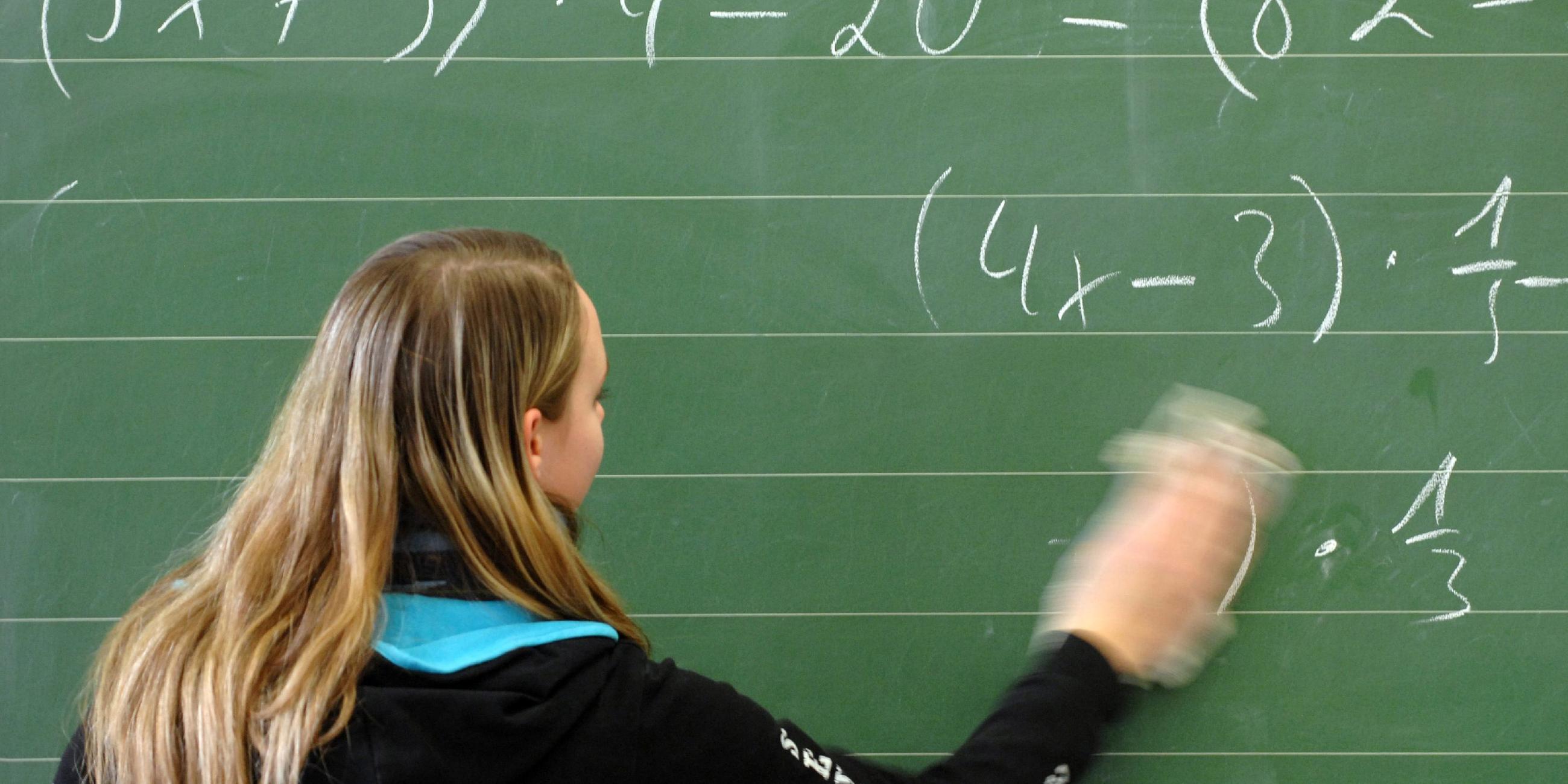Schülerin wischt im Klassenzimmer einer Hauptschule in Straubing die Tafel