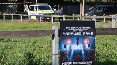 Polizisten sichern am 30.08.2026 in Aarau, in der Nordschweiz, den Bereich hinter einem Plakat ab, auf dem für eine Rave-Party geworben wird, bei der es zu einer Schießerei gekommen war.