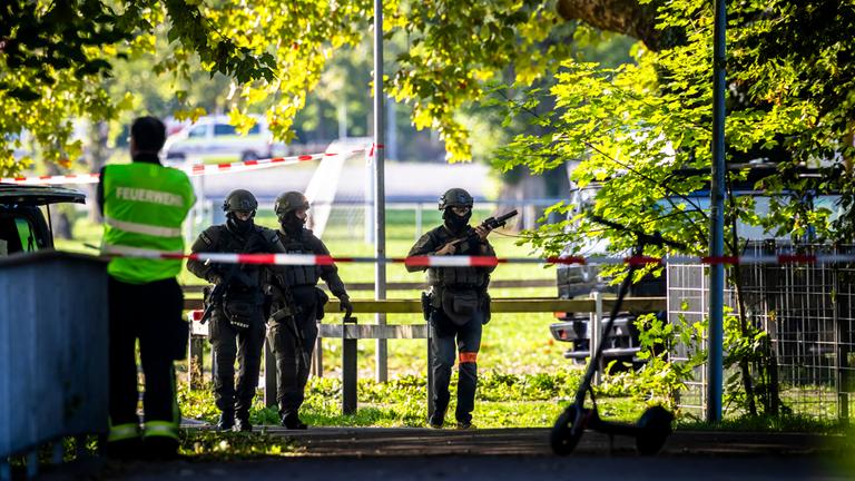 Bewaffnete Polizeibeamte patrouillieren in der Nähe der Pferderennbahn Schachen in Aarau, Schweiz, am 30.08.2026.