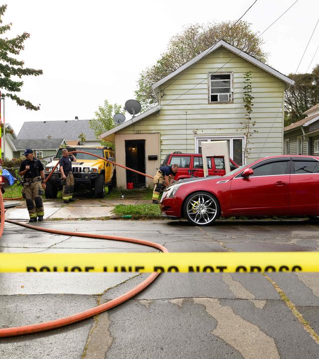 Feuerwehrleute entfernen Blutspuren vor dem Haus in Erie, Pennsylvania in dem am 10.10.2026 neun Mitglieder einer Familie bei einem mutmaßlichen Familienstreit ums Leben kamen.