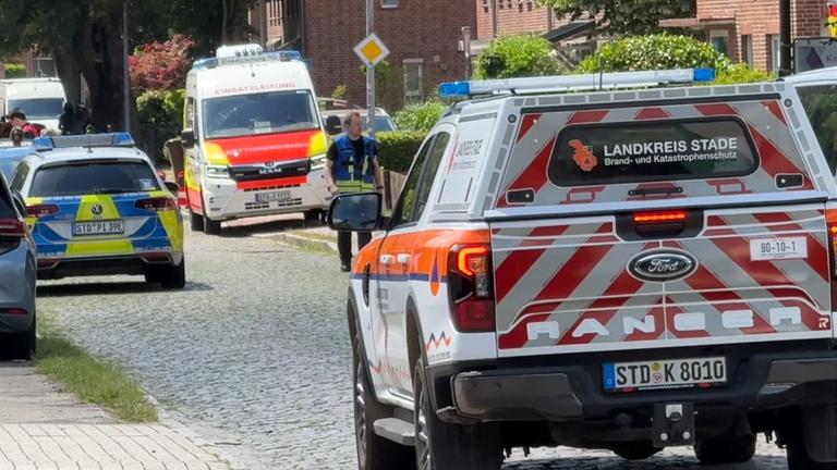 Niedersachsen, Stade: Einsatzkräfte stehen auf einer Straße in Stade.