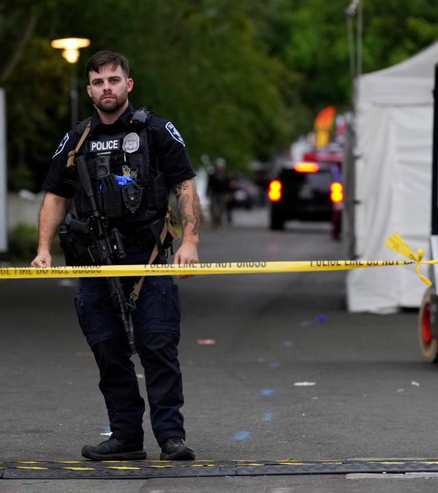 Polizeibeamte sichern mit Absperrband die Umgebung des Seattle Center. 