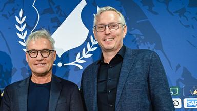 Ex-Geschäftsführer Markus Schütz und Frank Briel vor einer Hoffenheimer Sponsorenwand