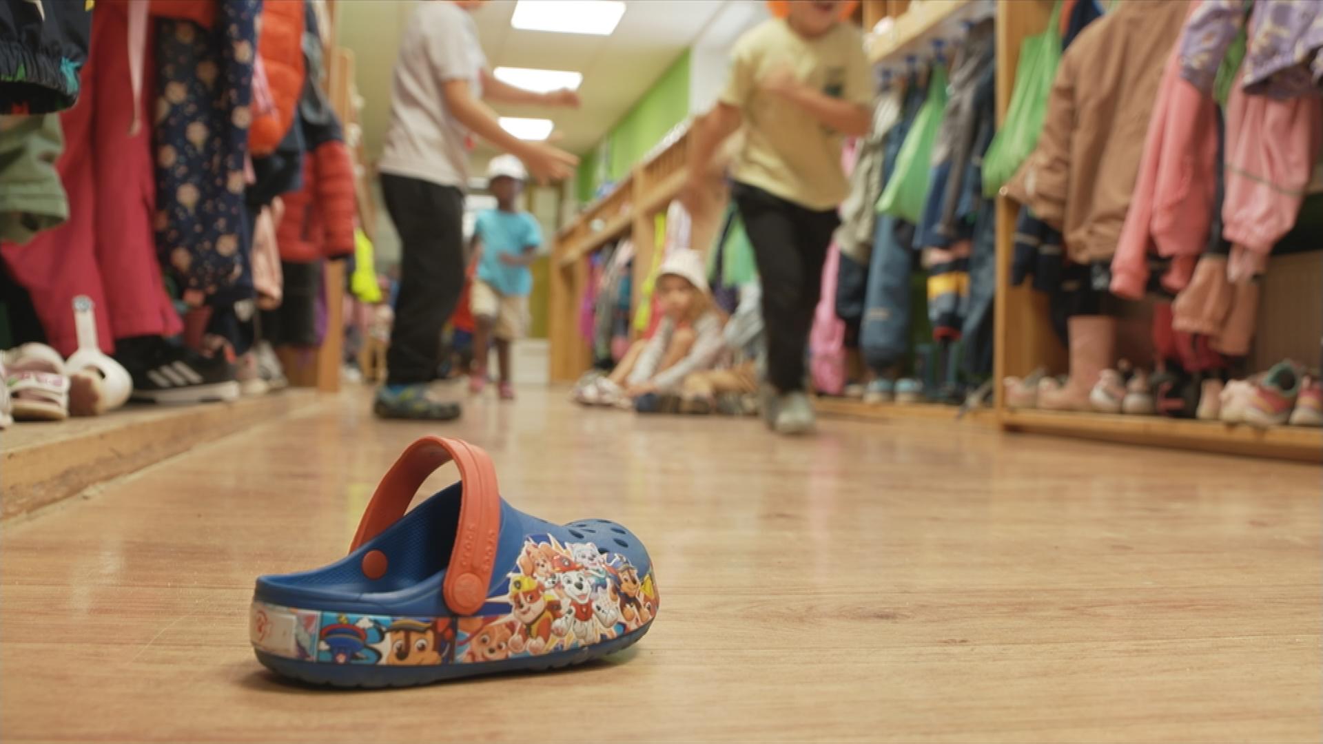 Auf dem Bild ist ein Kinderschuh auf dem Boden eines Kitaflurs zu sehen.