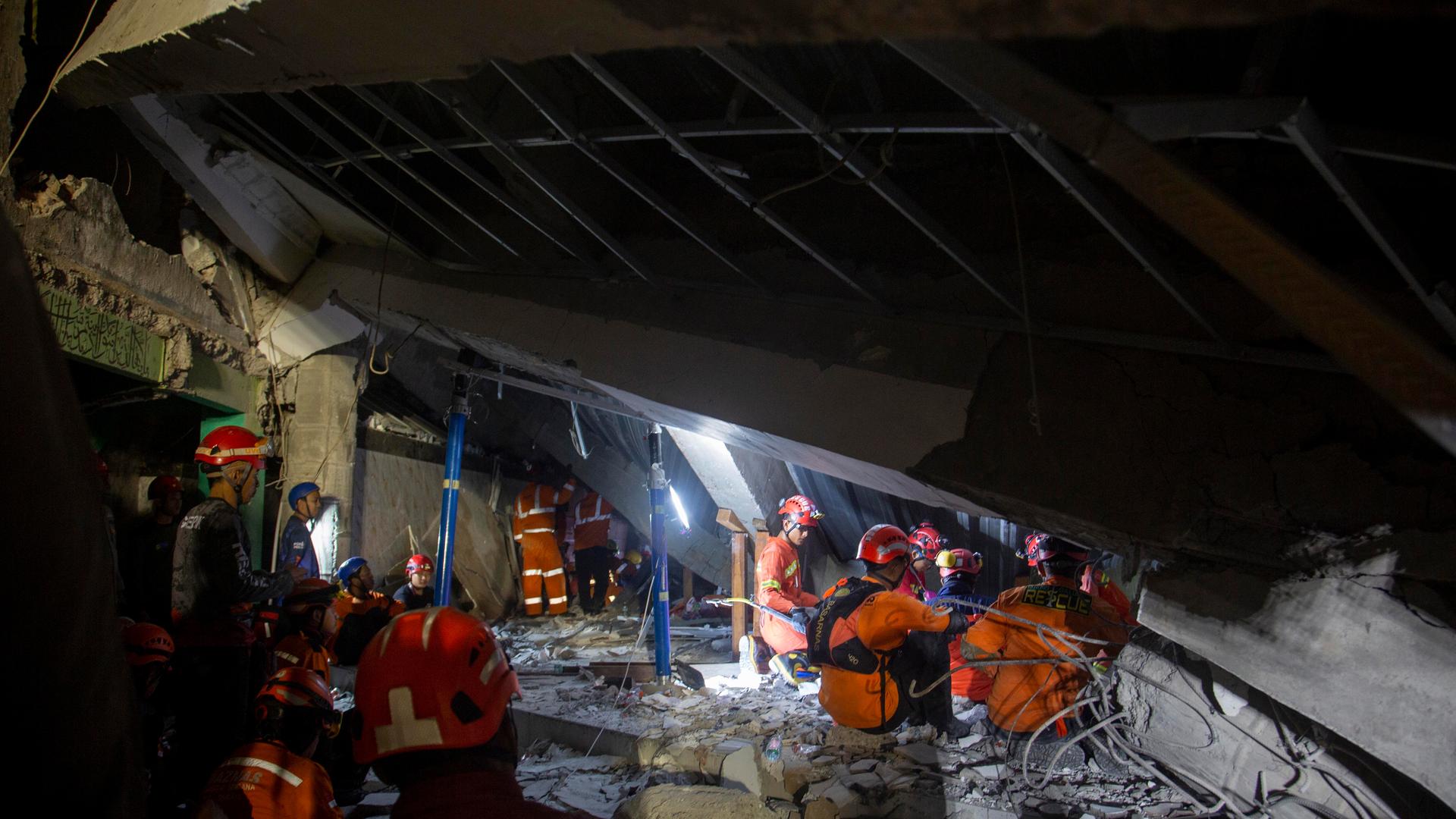 Rettungskräfte suchen am 30. September 2025 nach Überlebenden eines eingestürzten Schul-Gebäudes