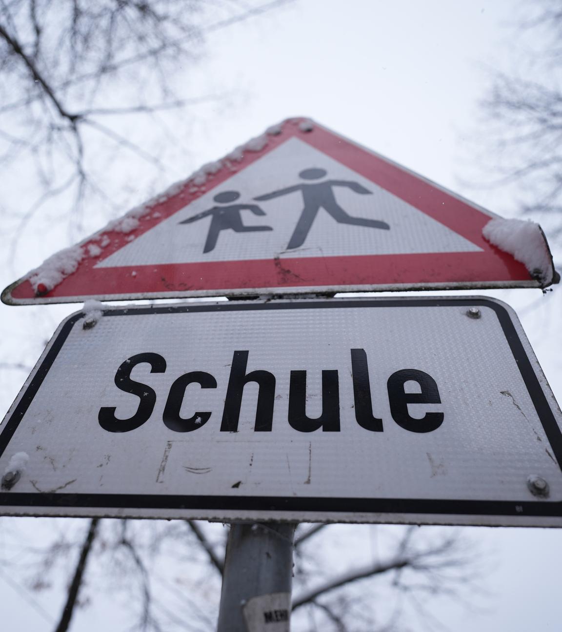 Schnee liegt auf einem Verkehrsschild und Hinweisschild mit der Aufschrift "Schule" vor einer Schule im Hamburger Stadtteil St. Georg am 08.01.2026.