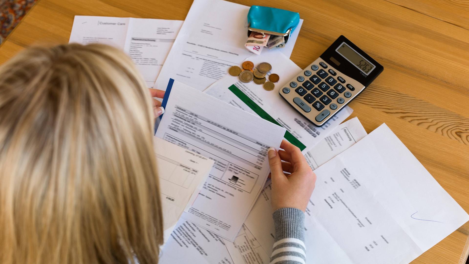 Frau sitzt über Rechnungen