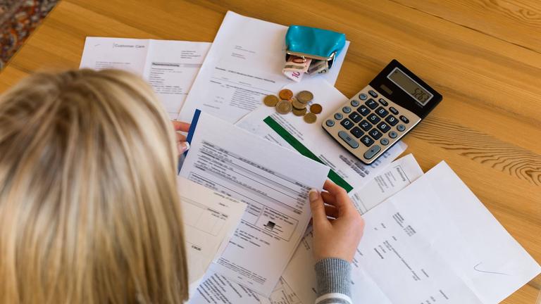 Frau sitzt über Rechnungen