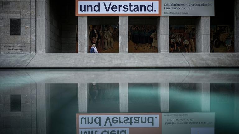  Ein Plakat mit der Aufschrift "Mit Geld und Verstand. Schulden bremsen, Chancen schaffen. Unser Bundeshaushalt." hängt über dem Eingang zum Bundesministerium der Finanzen.