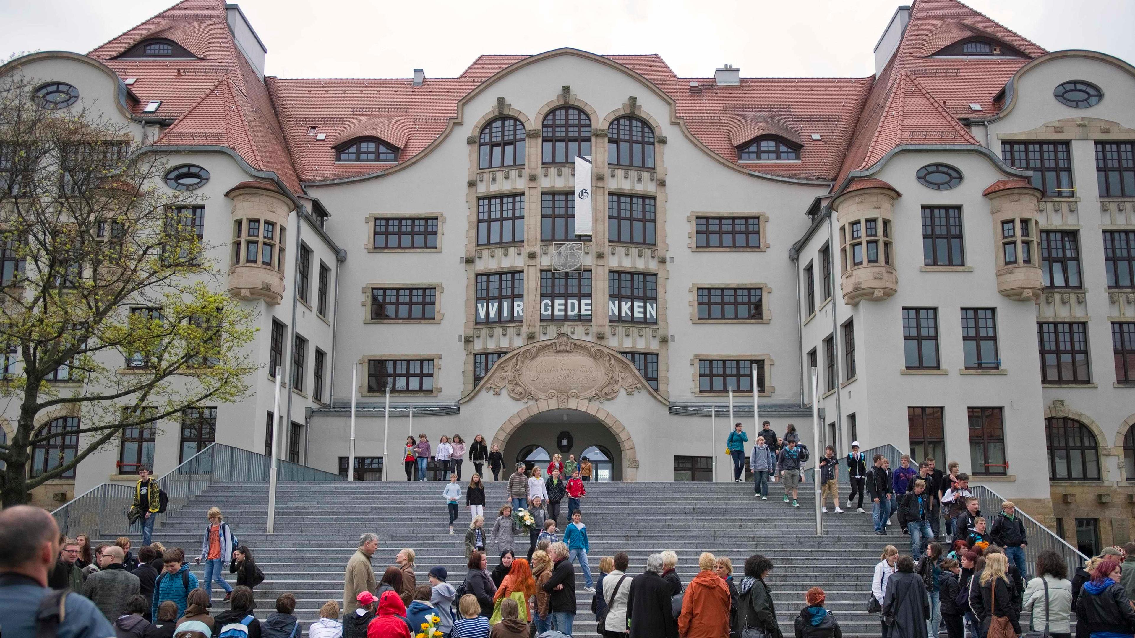Schüler stehen vor dem neu gestalteten Gutenberg-Gymnasium in Erfurt.