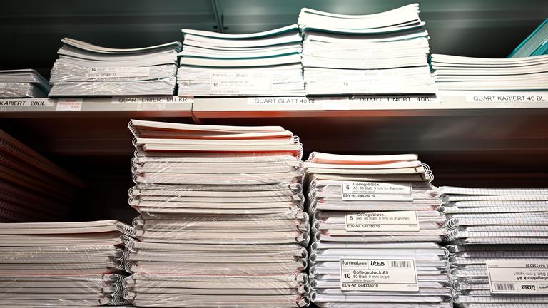 Stapel von Schulhefte und Blöcken in einem Regal.