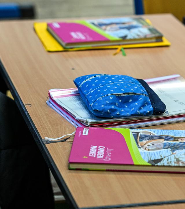 Schulmaterialien liegen auf Tisch im Klassenzimmer