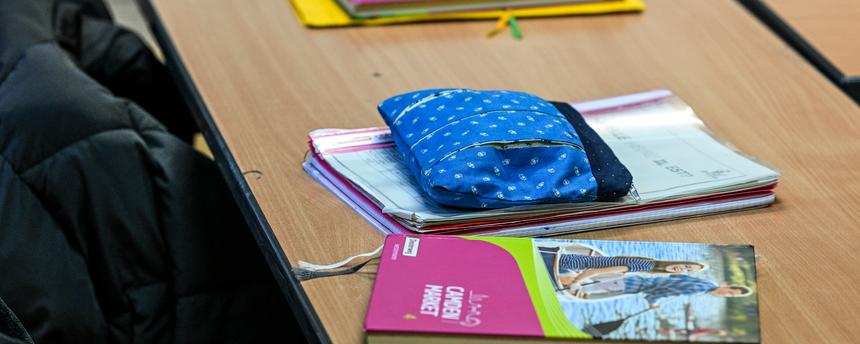 Schulmaterialien liegen auf Tisch im Klassenzimmer