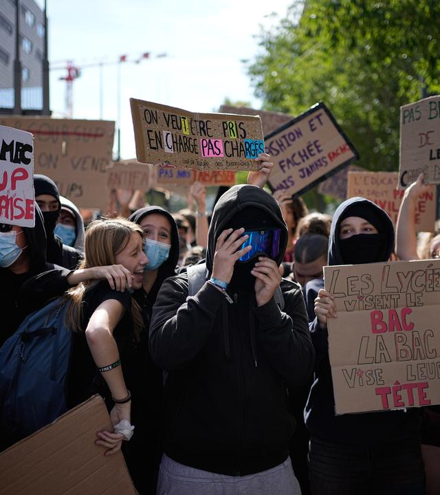 Ein Schüler hält ein Schild mit der Aufschrift "Wir wollen unterstützt und nicht überlastet werden" während einer Demonstration gegen unterfinanzierte Schulen vor einer Blockade vor einem Gymnasium.