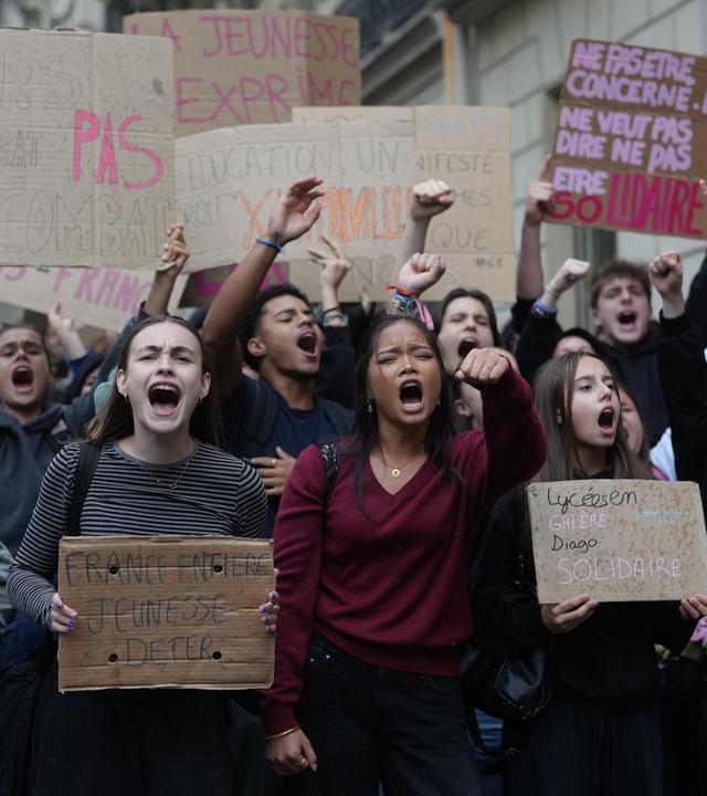 Schüler skandieren vor einem blockierten Gymnasium Parolen, um gegen die mangelnde Ausstattung der Schulen zu protestieren. 