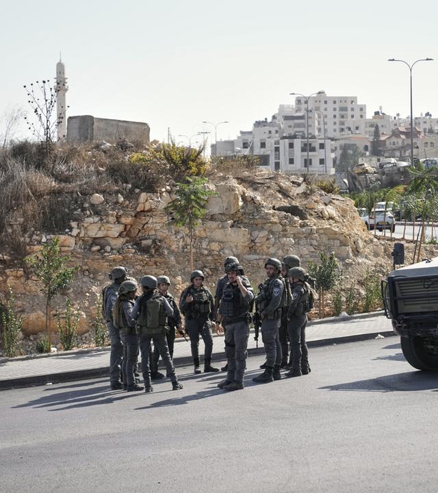 Palästinensische Gebiete, Hebron: Israelische Soldaten versammeln sich am Ort eines Schussangriffs, den palästinensische Bewaffnete an einer Kreuzung in der Nähe von Hebron im besetzten Westjordanland verübt haben.