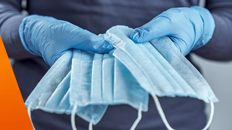 Hand hält Schutzmasken