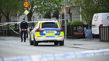 Einsatzfahrzeug und ein Polizist stehen am Einsatzort nach Schüssen am Vaksala-Platz im Zentrum von Uppsala, Schweden