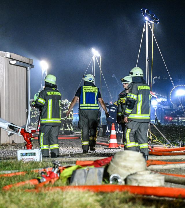 Feuerwehrleute sind beim Brand eines Schweinestalls im Einsatz. bei Brand in Ried, Bayern