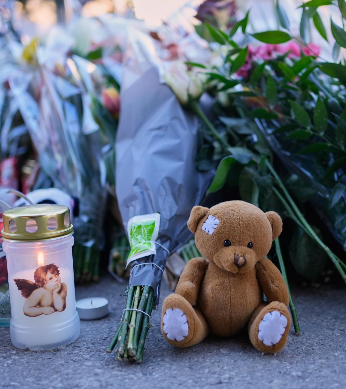 Kerzen und Stofftiere stehen in der Nähe der abgeriegelten Bar Le Constellation in Crans-Montana.