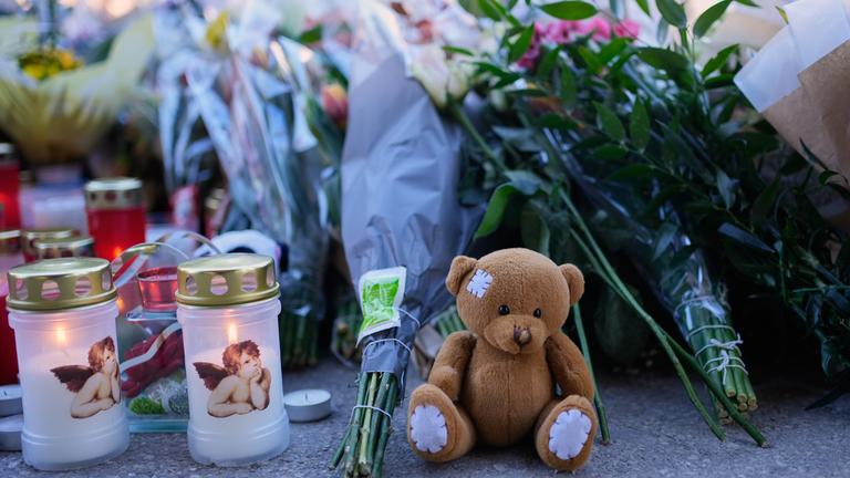 Kerzen und Stofftiere stehen in der Nähe der abgeriegelten Bar Le Constellation in Crans-Montana.