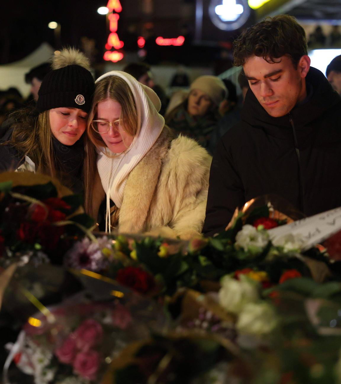 Menschen gedenken der Opfer des Brandes in der Bar "Le Constellation"