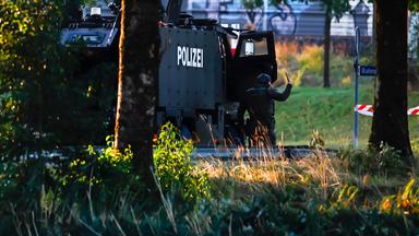 Bewaffnete Polizeibeamte mit einem gepanzerten Einsatzfahrzeug sperren eine Straße in der Nähe der Pferderennbahn Schachen in Aarau ab.
