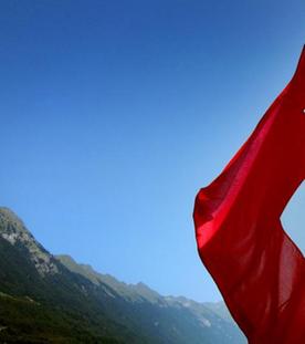 Schweizer Flagge vor einem Bergsee