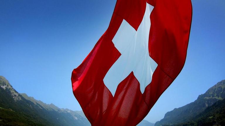 Schweizer Flagge vor einem Bergsee