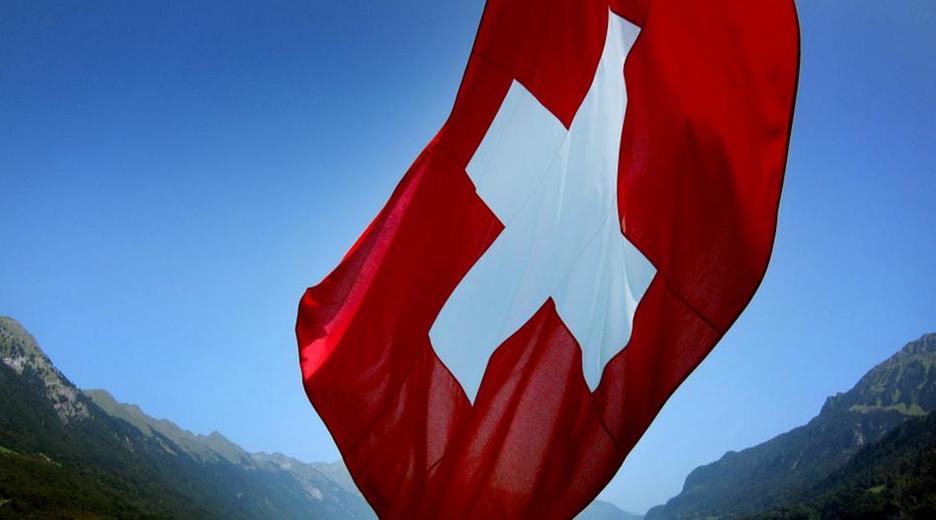 Schweizer Flagge vor einem Bergsee