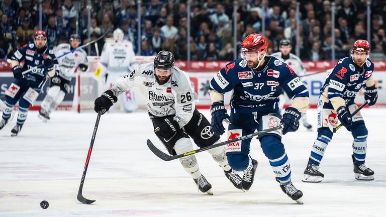 Kölns Dominik Uher (l) und Schwenningens Thomas Larkin kämpfen um den Puck.