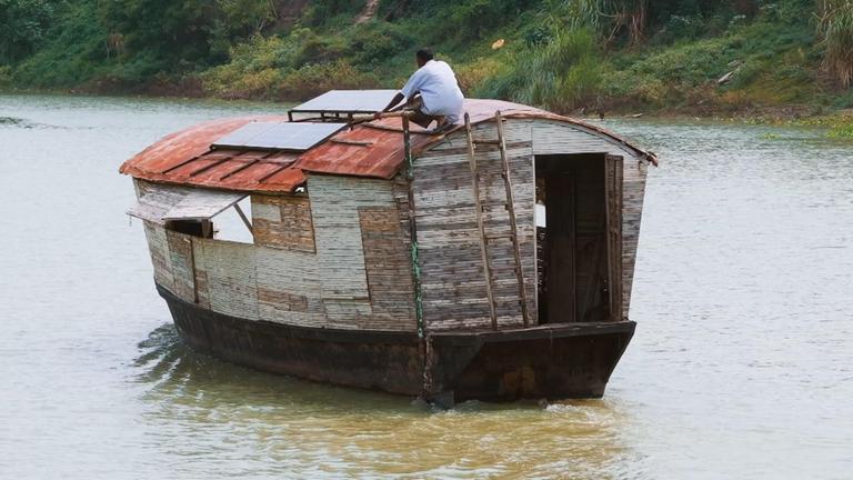 Ein Mensch sitzt auf einem fahrenden Boot