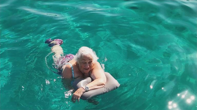 Seniorin schwimmt vor Capri im Meer