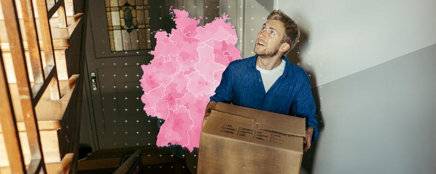 Mann trägt Umzugskarton die Treppe hoch. Im Hintergrund ist eine Deutschlandkarte, eingefärbt nach Höhe der Mietpreise, zu sehen.