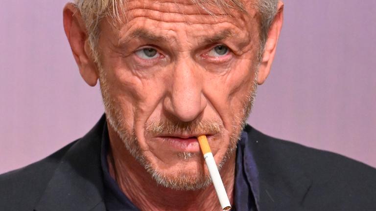 Der Schauspieler Sean Penn mit einer Zigarette im Mund. 