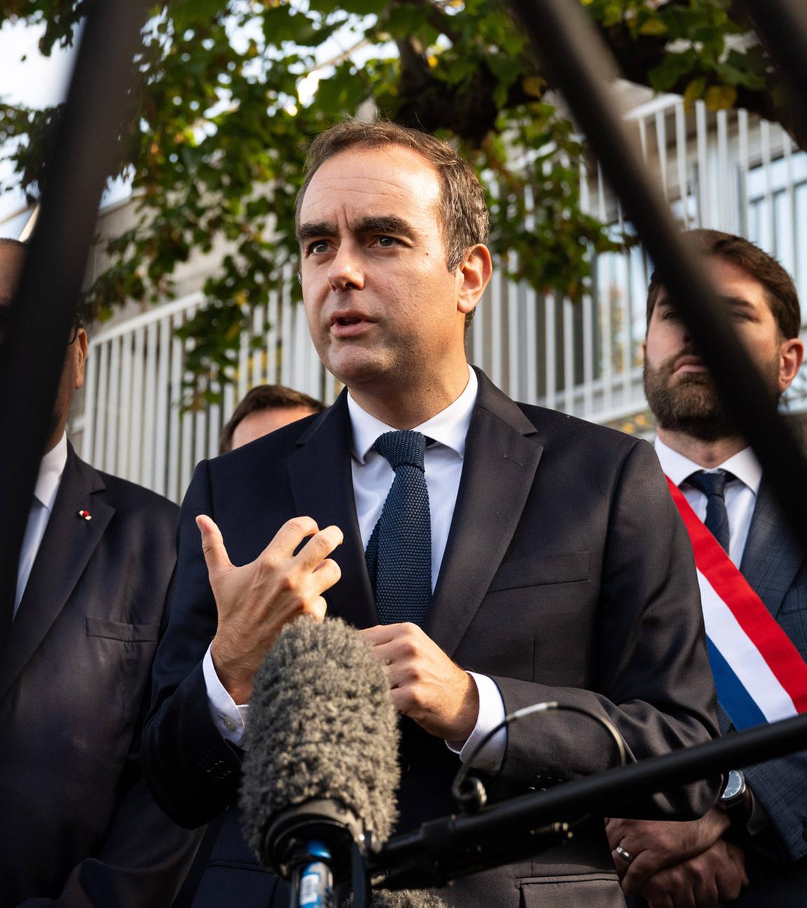 Der französische Premierminister Sébastien Lecornu (Mitte), flankiert vom Abgeordneten der Droite Républicaine, Vincent Jeanbrun (links), und dem Polizeipräfekten von Paris, Laurent Nuñez (rechts), spricht am 11. Oktober 2025 nach einem Besuch einer Polizeiwache in Hay-les-Roses im Süden von Paris mit Journalisten.