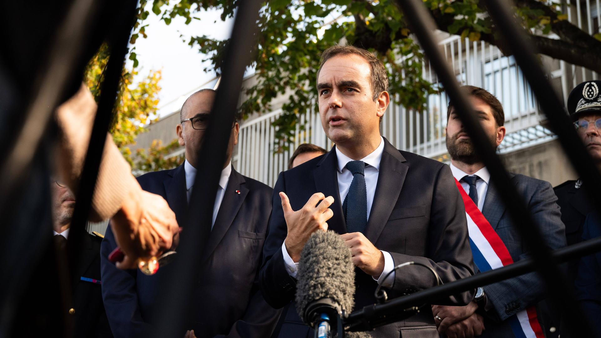 Der französische Premierminister Sébastien Lecornu (Mitte), flankiert vom Abgeordneten der Droite Républicaine, Vincent Jeanbrun (links), und dem Polizeipräfekten von Paris, Laurent Nuñez (rechts), spricht am 11. Oktober 2025 nach einem Besuch einer Polizeiwache in Hay-les-Roses im Süden von Paris mit Journalisten.