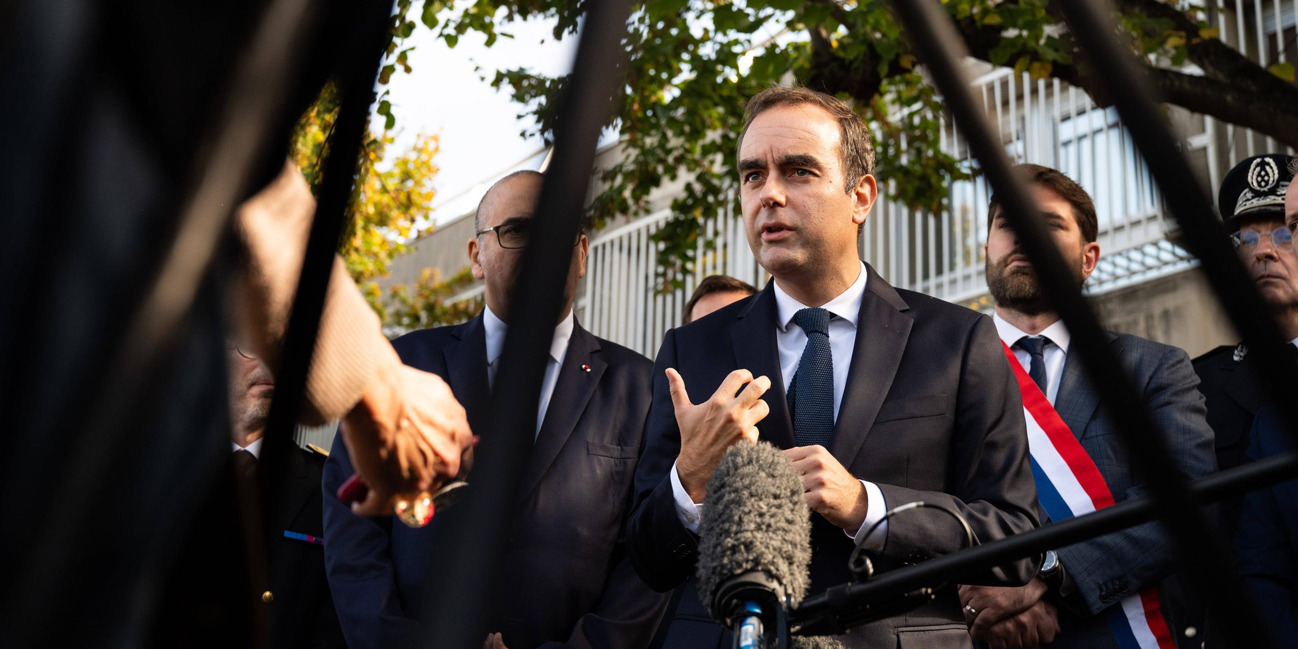 Der französische Premierminister Sébastien Lecornu (Mitte), flankiert vom Abgeordneten der Droite Républicaine, Vincent Jeanbrun (links), und dem Polizeipräfekten von Paris, Laurent Nuñez (rechts), spricht am 11. Oktober 2025 nach einem Besuch einer Polizeiwache in Hay-les-Roses im Süden von Paris mit Journalisten.