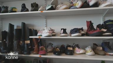 Verschiedene Kinderschuhe in einem Regal.