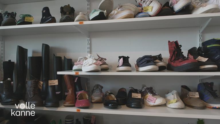 Verschiedene Kinderschuhe in einem Regal.